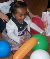 the bambino on her first birthday surrounded with balloons