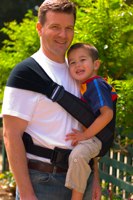 man carrying boy in scootababy