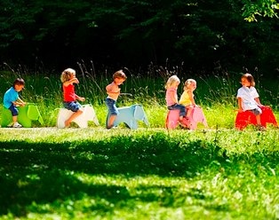 kids riding on eames elephants outdoors